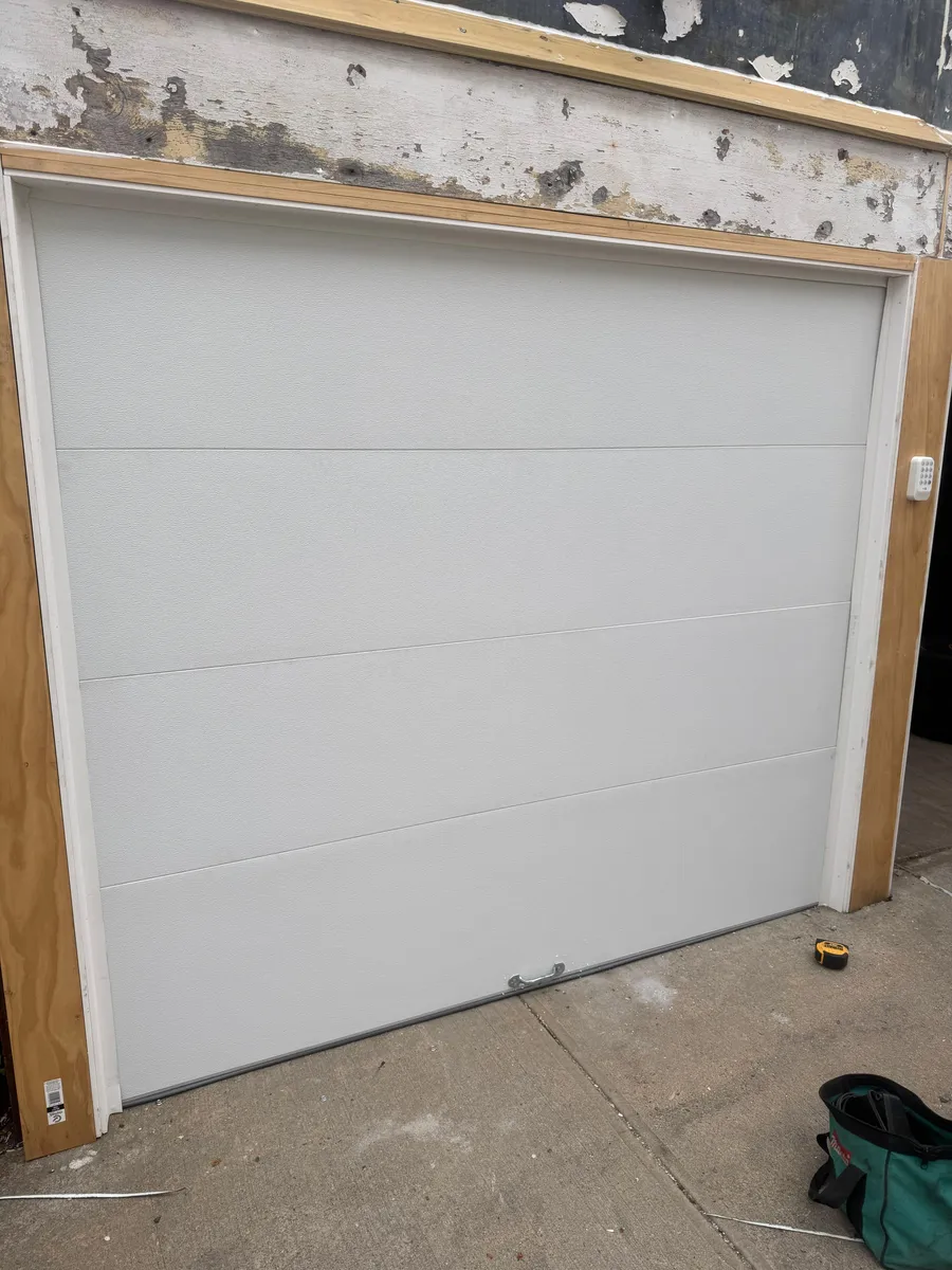 New white flush-panel insulated garage door installed during a garage renovation in Westchester County, NY
