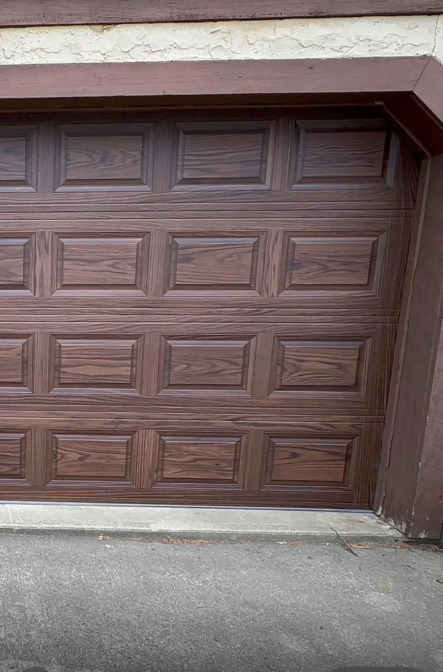 Mahogany wood-grain raised-panel garage door after full replacement in Suffern, NY